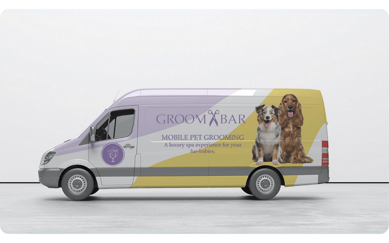 A picture of a mobile grooming van with dog images and the GROOMBAR logo on the side.