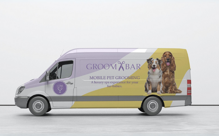 A picture of a mobile grooming van with dogs on the side and the GROOMBAR Logo